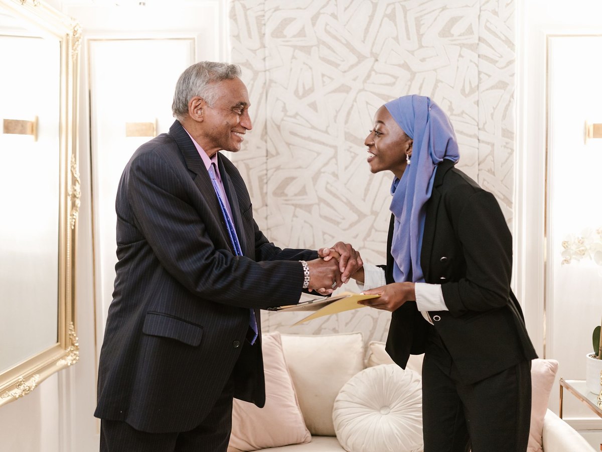 A man and a woman shaking hands in a sitting room