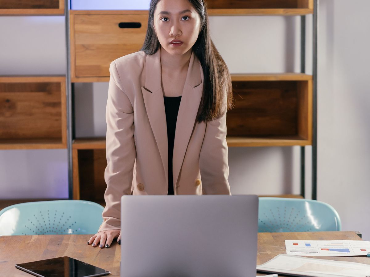 A woman standing at a laptop on a desk
